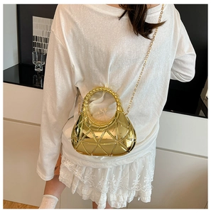 Détail du sac hobo doré métallique avec texture géométrique porté par un mannequin