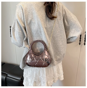 Détail du mini sac violet à texture géométrique et élégante bandoulière dorée