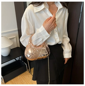 Détail du sac géométrique rose doré avec finition miroir et fine bandoulière chaîne