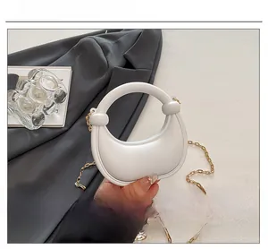 Detail of off-white half-moon bag with circular handle and gold chain strap