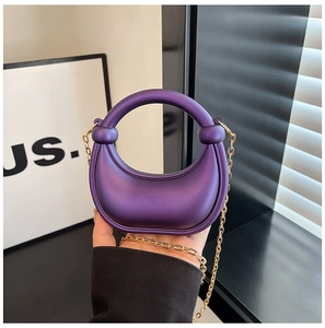 Detail of purple crescent mini bag with integrated handle and gold chain strap