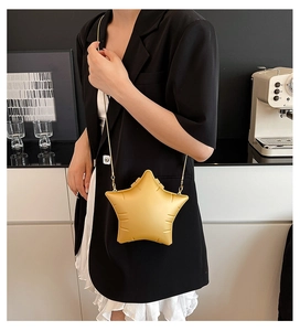 Model wearing yellow star-shaped crossbody bag with gold chain and matte finish