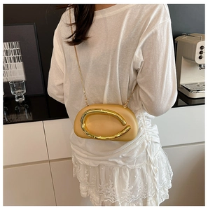 Detail view of beige acrylic crossbody bag with gold U-shape clasp and chain strap