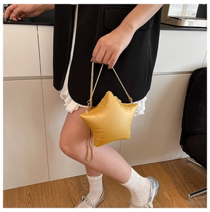 Detailed view of a bright yellow star-shaped crossbody bag with gold chain strap