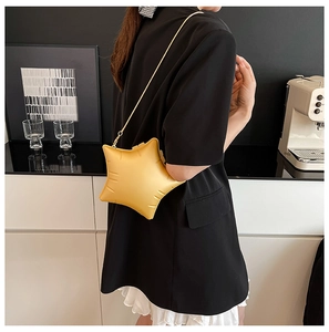 Detail of yellow star-shaped crossbody bag with embossed texture and gold chain strap