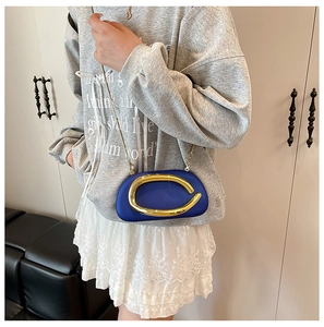 Detail of trendy blue acrylic evening bag with a large gold buckle and metal chain strap