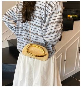 Model wearing a marble-textured hard shell bag with gold metal hardware and chain strap