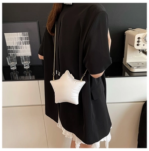 White star-shaped crossbody bag with gold chain strap shown from a side-rear perspective