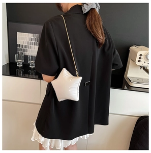 Chic white star-shaped quilted shoulder bag with gold chain strap shown in a lifestyle scene