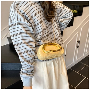 Chic beige cloud bag with elegant gold sculptural handle and fine chain strap detail