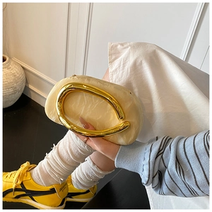 Detail of cream marble-textured clutch bag with a large polished gold oval handle