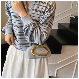 Detail of light blue velvet clutch with gold metal ring buckle and chain strap