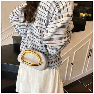 Detail view of a light blue evening clutch featuring a large gold metallic ring handle