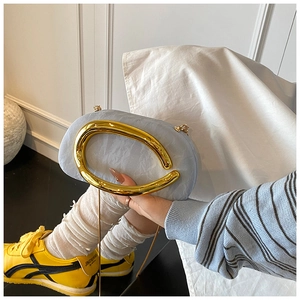 Close-up of light blue pleated clutch bag with large oval gold metal handle and chain