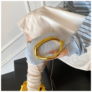 Detail of light blue marble clutch with large gold oval handle and chain strap