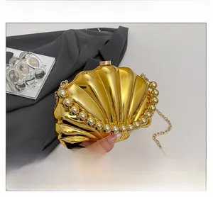 Detailed view of the gold shell-shaped mini bag with a metallic mirror finish and chain