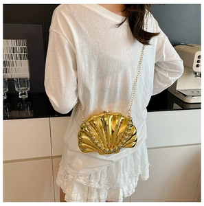 Detail of gold shell chain bag with pearl trim and metallic finish for women