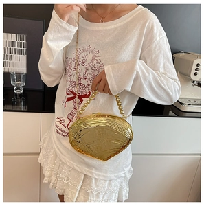 Golden shell-shaped acrylic evening clutch with beaded handle and metal chain strap