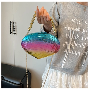 Close-up of shell-shaped acrylic bag with iridescent gradient finish and gold bead handle