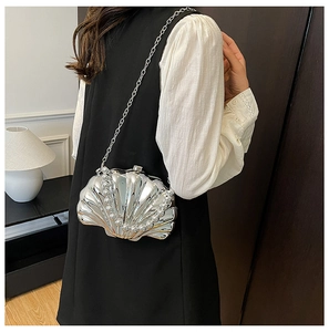Detailed view of silver shell-shaped mini bag with pearly trim and chain strap
