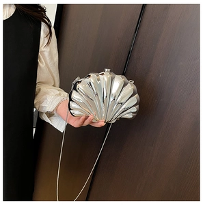 Close-up of silver shell evening bag with metallic mirror finish and chain strap