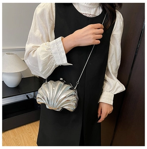 Detail of silver shell-shaped evening bag with metallic texture and sleek chain strap