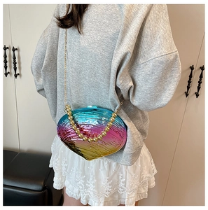 Detailed view of iridescent acrylic shell clutch bag with gold beads and chain