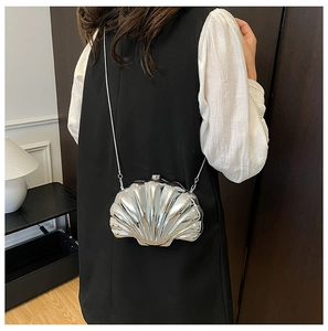 Detailed view of silver shell-shaped mini bag with mirror finish and metal chain strap
