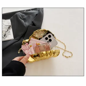Detailansicht der goldenen Muschel-Clutch mit Platz für Handy und Kosmetikartikel