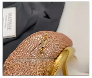 Detail of rose gold rhinestones and shiny gold metal chain on a luxury evening clutch bag