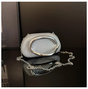 Macro shot of silver rhinestone evening bag with oval metal handle and chain strap