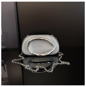 Detail of silver rhinestone evening bag with glossy metal handle and chain strap