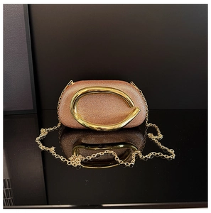 Macro view of rose gold evening clutch featuring sparkling rhinestones and a gold handle