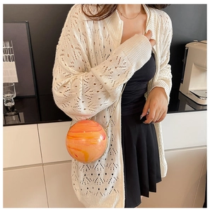 Detail of spherical marble pattern chain bag with gold metal zipper and cosmic texture