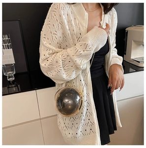 Model wearing a round spherical smoky grey acrylic chain bag with gold metal frame
