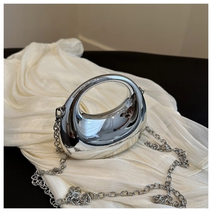 Close-up of a silver crescent moon evening clutch with a polished mirror finish metal