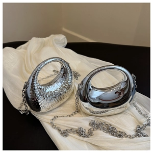 Detailed comparison of textured and smooth silver crescent evening bags with chain straps