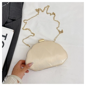 Close-up of champagne gold evening bag with textured ripples and metal clasp