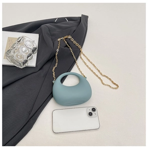 Detailed view of mini Morandi blue arc bag with gold chain and size comparison