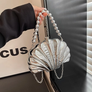Modern silver shell-shaped evening bag with metallic finish and beaded handle