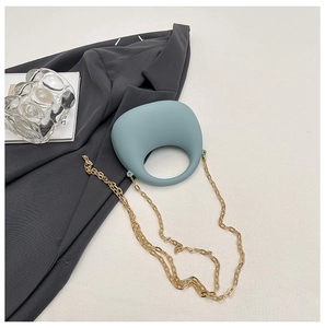 Detail of light blue pebble bag with circular cutout handle and golden metal chain strap