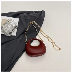 Minimalist burgundy acrylic handbag with smooth oval shape and gold chain strap