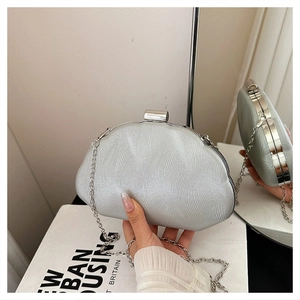 Detail of silver evening clutch with rippled texture and elegant metal clasp buckle