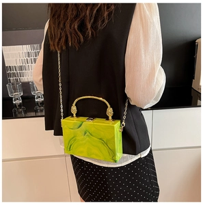 Green marble acrylic box clutch featuring lion head detail and golden chain strap