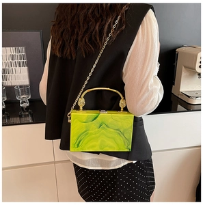 Detail of green acrylic marble box bag with gold metal handle and chain strap