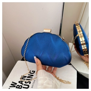 Detail of royal blue evening clutch with vertical wave texture and gold metal clasp