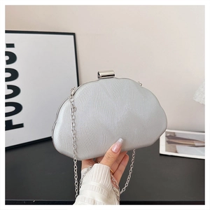 Detail of silver evening clutch featuring ripple texture, shimmer finish and metal chain