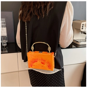 Detailed look at the orange marble acrylic box bag with gold handle and chain strap