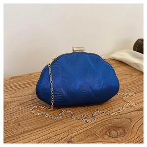 Detail view of royal blue shell evening bag with ripple texture and gold chain strap