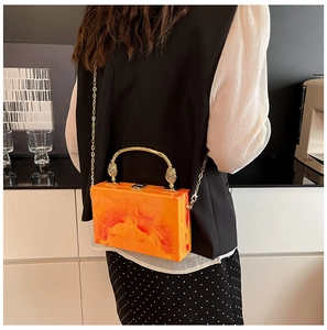 Detail of orange marble acrylic box bag with vintage gold handle and chain strap